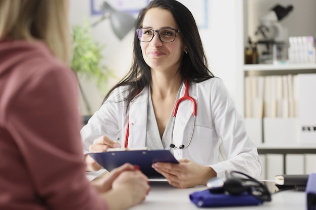 Mulher médica feliz e sorridente está recebendo paciente na clínica conceito ivf de sucesso