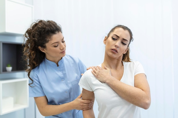 Mulher médica osteopata em uniforme médico consertando pacientes mulheres ombro e articulações nas costas na clínica de terapia manual durante a visita Osteopata profissional durante o trabalho com o conceito de paciente