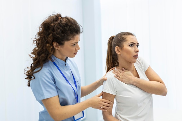 Mulher médica osteopata em uniforme médico consertando pacientes mulheres ombro e articulações nas costas na clínica de terapia manual durante a visita Osteopata profissional durante o trabalho com o conceito de paciente