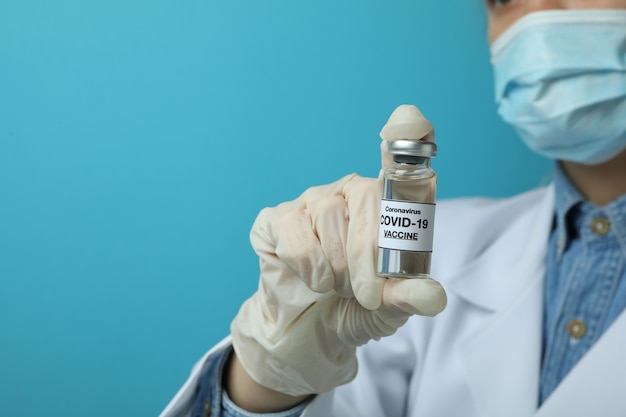 Mulher médica segura o frasco com a vacina COVID - 19