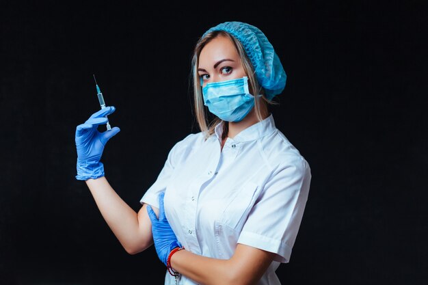 Mulher médica segura uma seringa na mão na frente dela. conceito de medicina e cosmetologia