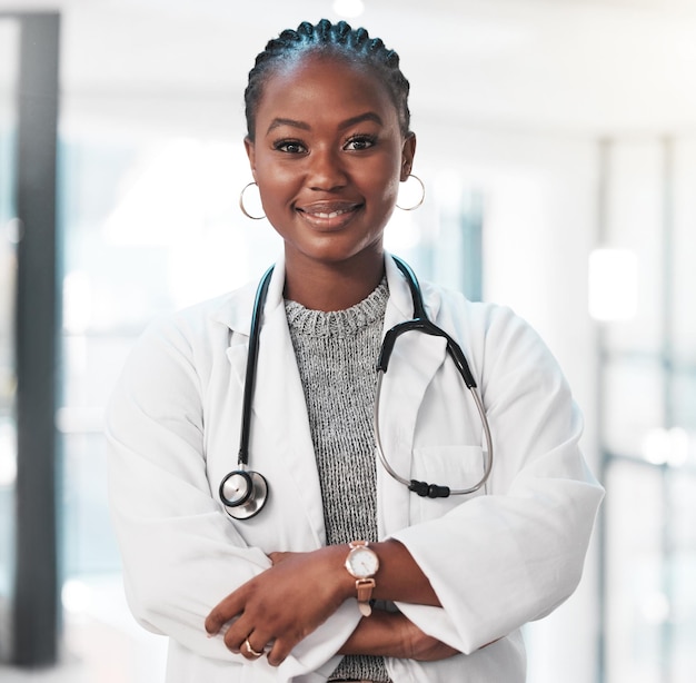 Mulher médico e braços cruzados com retrato feliz bem-estar e cuidados de saúde ou profissional confiante na clínica Sorrir médico e serviço de ajuda com estetoscópio cuidados e apoio para cirurgia