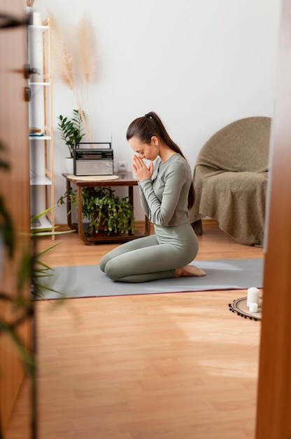 Foto mulher meditando em casa no tapete