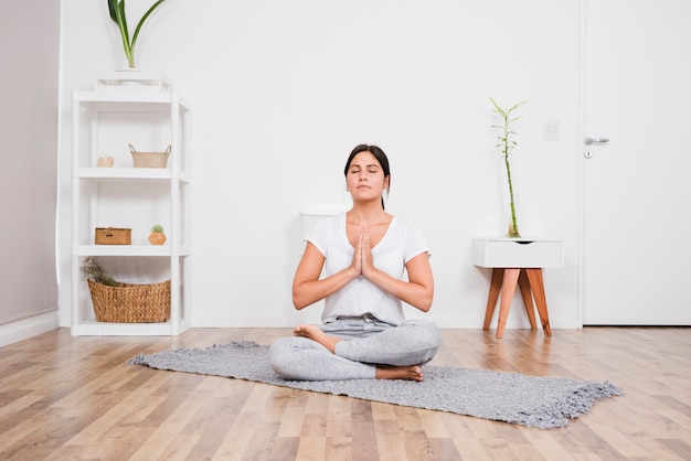 Mulher meditando em casa