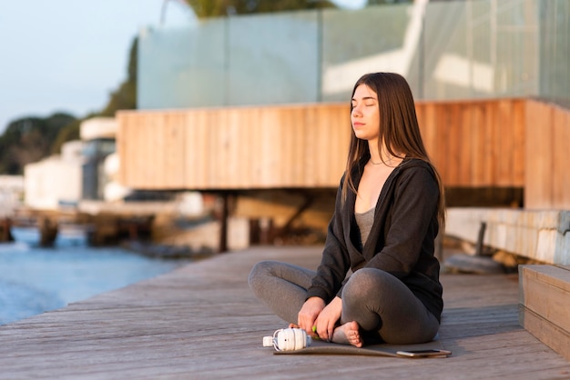 Mulher meditando junto ao mar