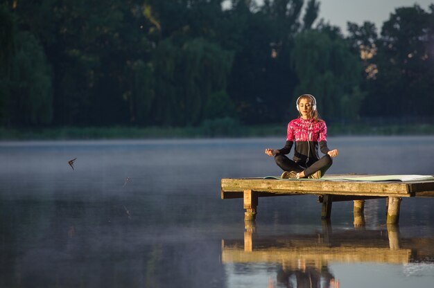 Mulher meditando na natureza no rio. ioga