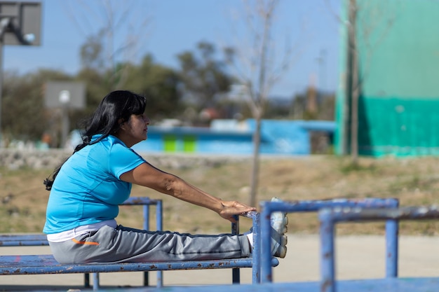 Mulher mexicana idosa treinando em um parquinho