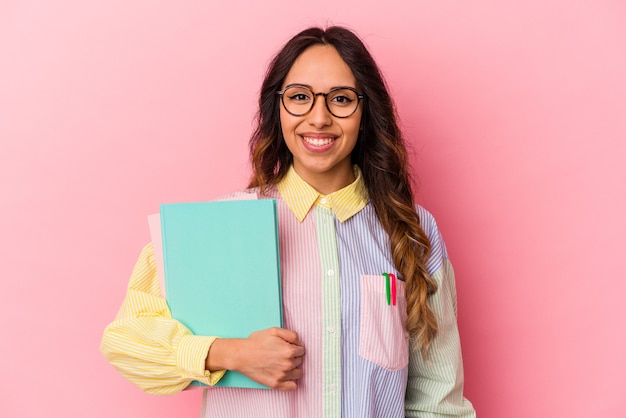 Mulher mexicana jovem estudante isolada em fundo rosa feliz, sorridente e alegre.