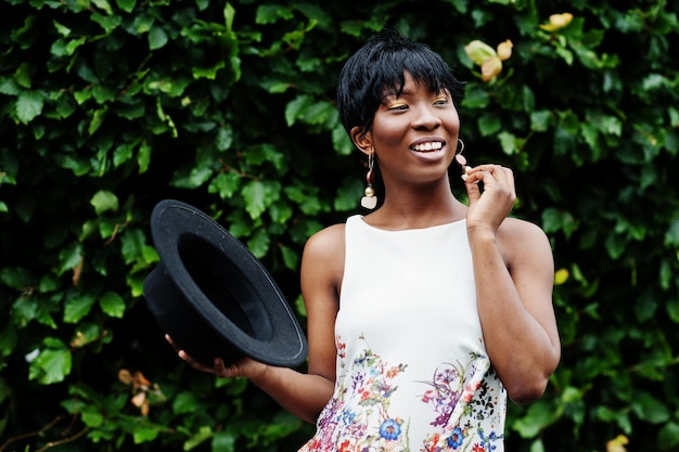 Mulher modelo americano africano incrível em calças verdes e chapéu preto posou com emoções diferentes no parque