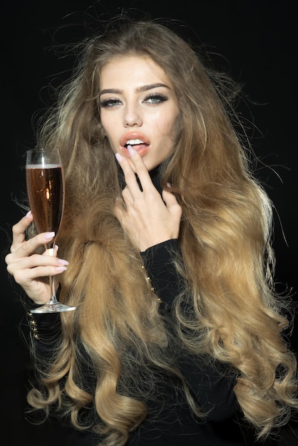 Mulher modelo sexy com taça de champanhe Mulher atraente com cabelo longa e saudável em vestido preto