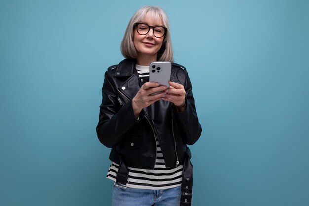 Mulher moderna de meia-idade inteligente com cabelos grisalhos assistindo vídeo na internet usando telefone inteligente em