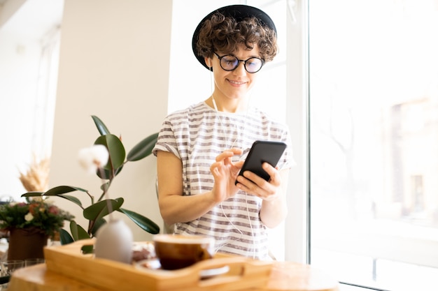 Mulher moderna usando smartphone no café