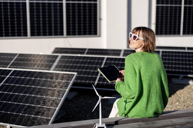 Mulher monitora a produção de energia da usina solar com um tablet digital