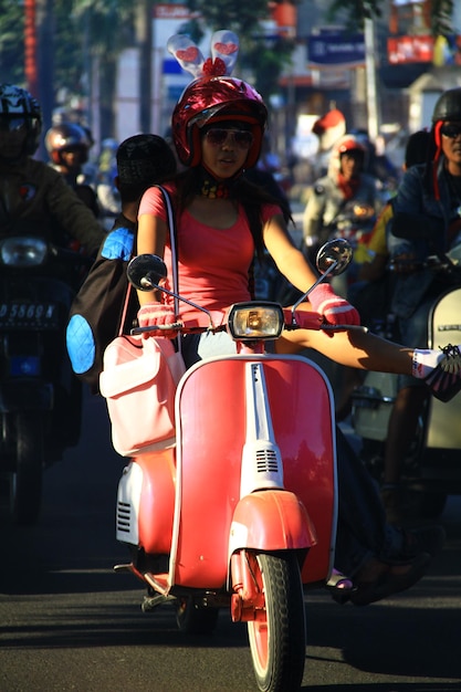 Foto mulher montando uma scooter na estrada da cidade