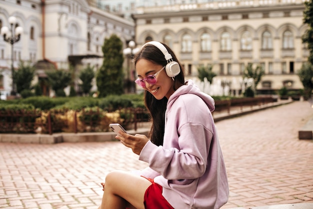 Mulher morena atraente com fones de ouvido ouve música