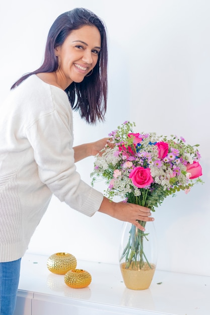 Mulher morena bonita, apreciando seu buquê de flores