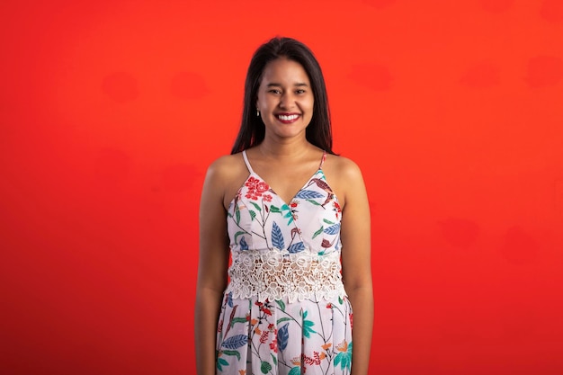 Mulher morena brasileira em vestido estampado de flores em estúdio