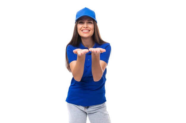 Mulher morena caucasiana muito jovem e bem cuidada em camiseta uniforme e boné com maquete para impressão