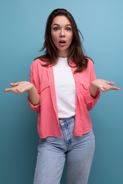 Mulher morena confusa com cabelo abaixo dos ombros em uma camisa encolhe os ombros