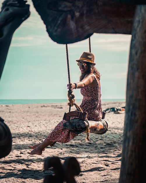 Mulher morena curtindo swing na praia