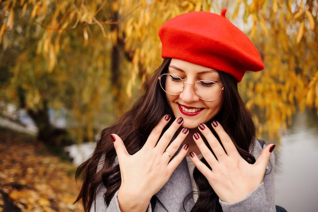 Mulher morena feliz em uma boina vermelha elegante