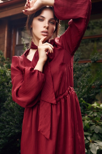 Mulher morena linda moda vestido vermelho no jardim