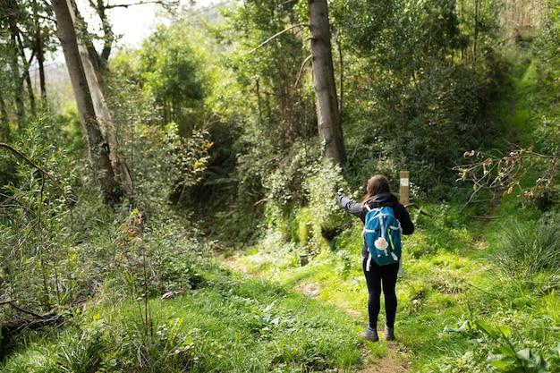 Mulher morena peregrina fazendo a caminhada do caminho de santiago no caminho de são joão