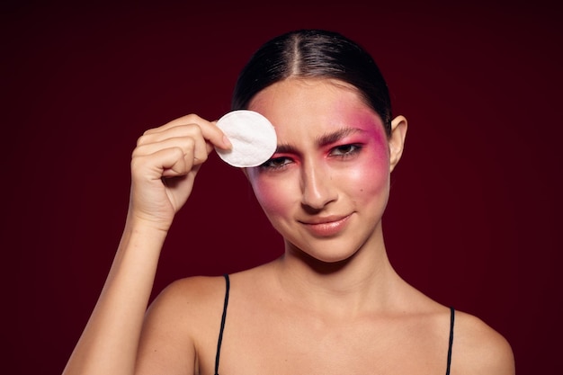 Mulher morena sexy maquiagem de rosto rosa posando olhar atraente cuidados com a pele vista recortada inalterada