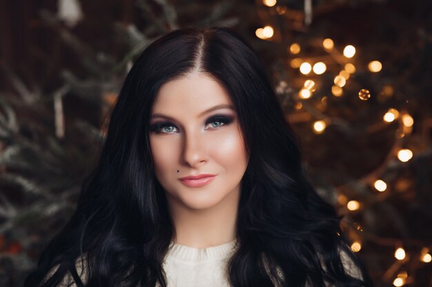 Mulher morena sorridente com decoração de Natal