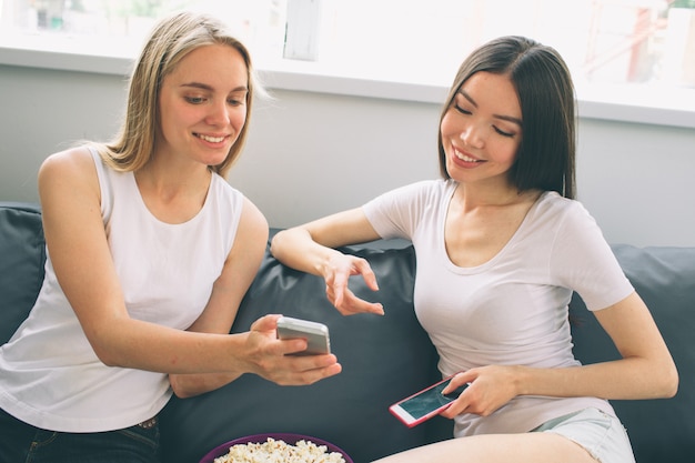 Mulher mostrando a amiga o telefone celular