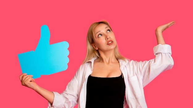Mulher mostrando banner parecendo feliz animado em fundo rosa