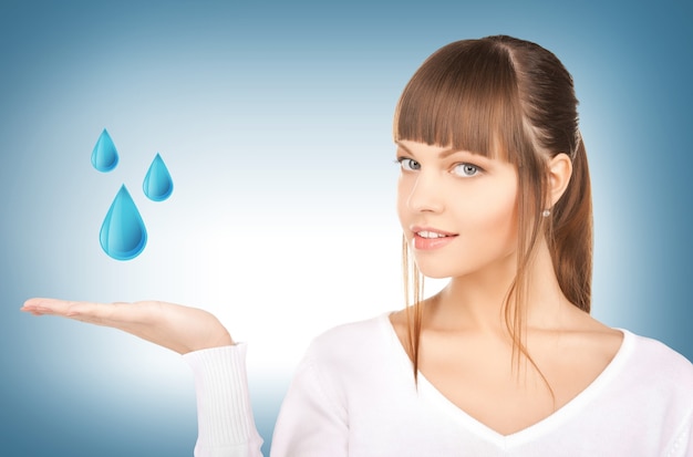 mulher mostrando gotas de água azul na mão