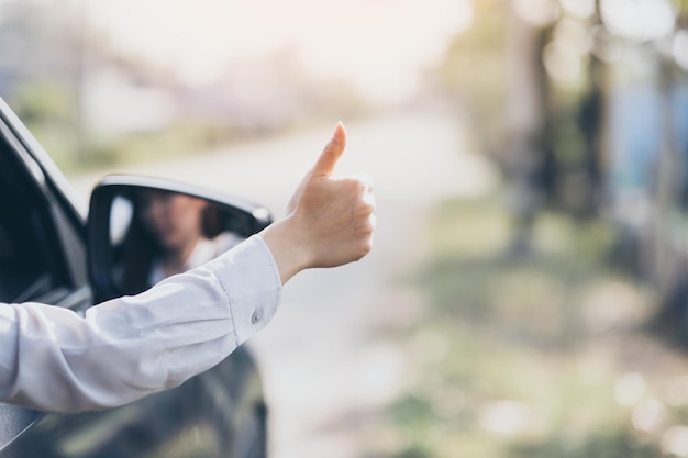 Mulher mostrando os polegares enquanto viaja de carro