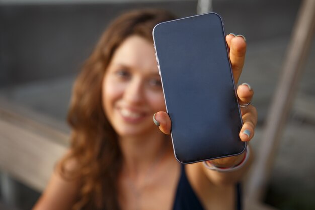 mulher mostrando tela de smartphone