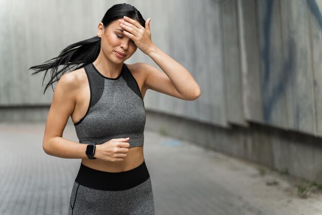 Mulher motivada cansada correndo pela manhã ao longo do estádio Garota atlética tendo executado treino Cuidados de saúde e conceito de esporte