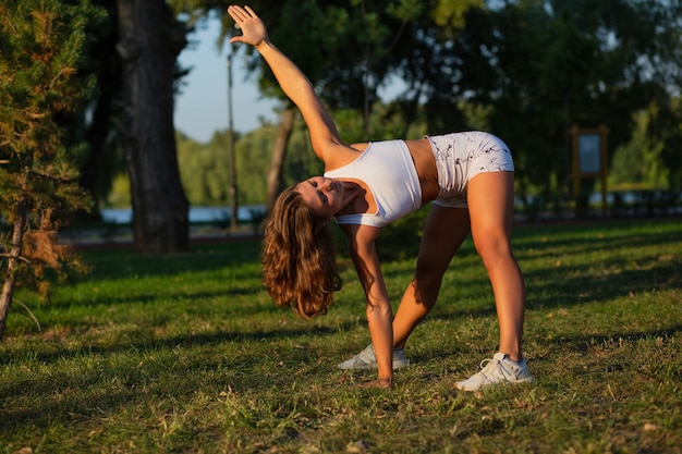 Mulher motivada com figura atlética fazendo pilates e alongamento