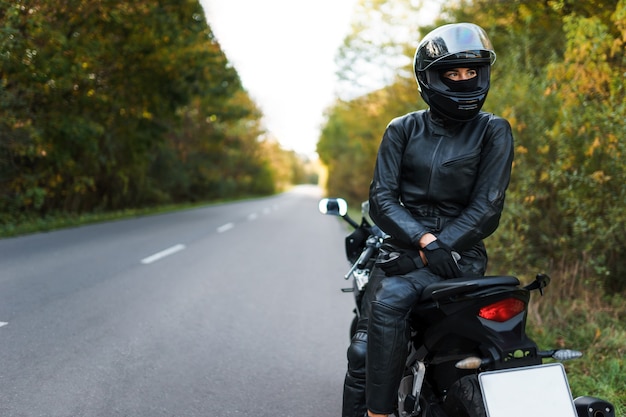 Mulher motociclista sentada em uma motocicleta