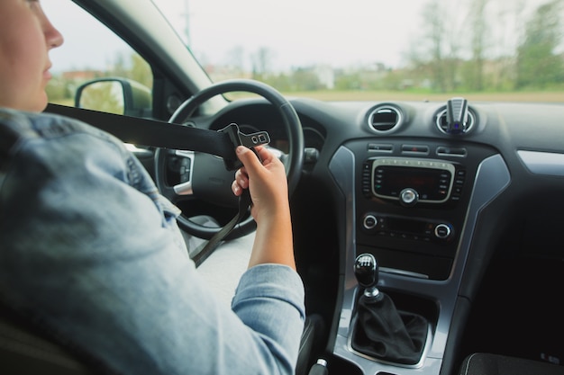 Mulher motorista apertando o cinto de segurança antes de dirigir, conceito de direção segura