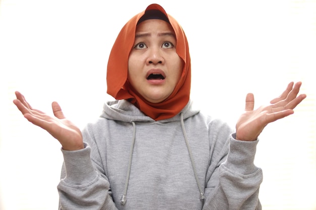 Mulher muçulmana asiática atordoada expressão chocada olhando para cima boca aberta esperando algo ruim acima