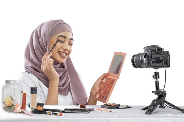 Mulher muçulmana asiática blogueira de beleza tutorial de maquiagem nos olhos e criação de vídeos