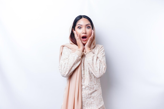 Mulher muçulmana asiática chocada usando hijab com a boca aberta isolada por fundo branco