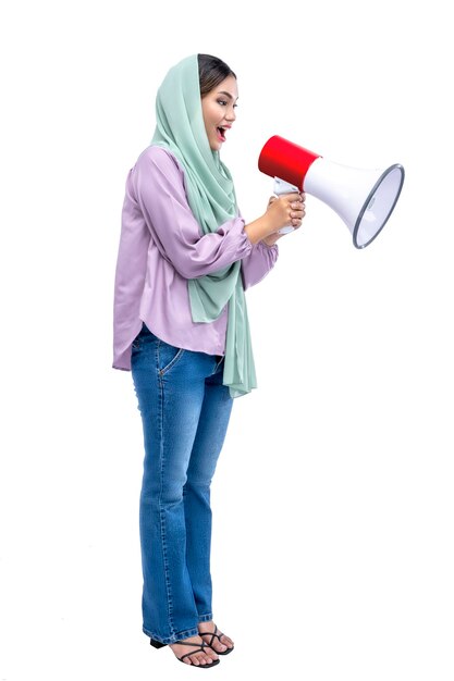 Mulher muçulmana asiática em um lenço na cabeça gritando em um megafone