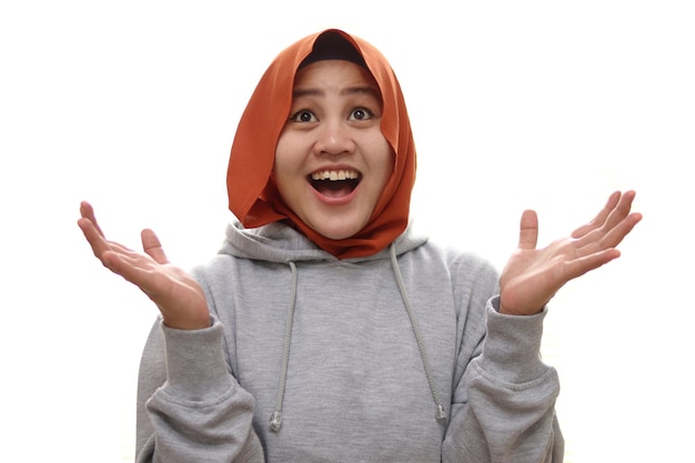 Mulher muçulmana asiática feliz feliz surpreendida ganhando gesto de saudação esperando algo de cima