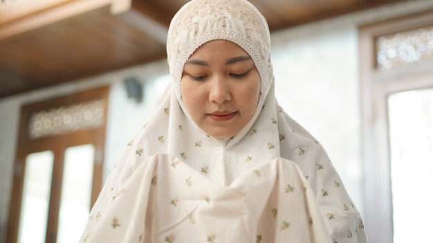 Mulher muçulmana asiática rezando esperançosamente na mesquita