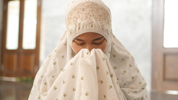 Mulher muçulmana asiática rezando esperançosamente na mesquita