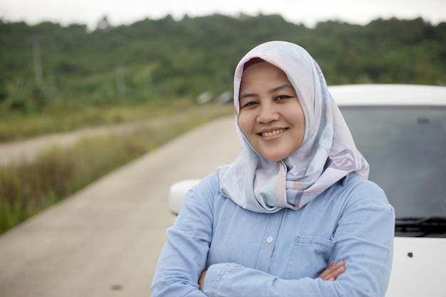 Mulher muçulmana asiática sorrindo enquanto dirige seu carro em viagem de férias conceito de compartilhamento de passeio de carro