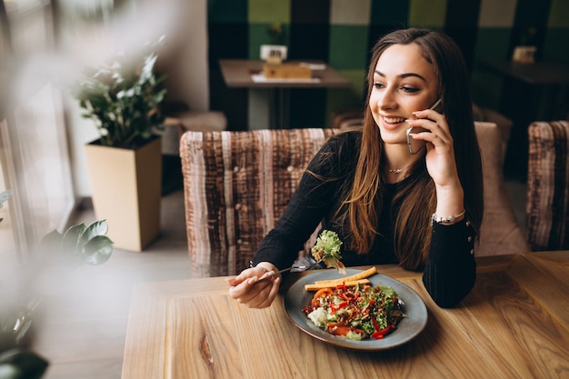 Foto mulher muçulmana com salada falando ao telefone