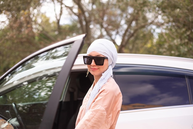 Mulher muçulmana Cutr está de pé perto do carro moderno