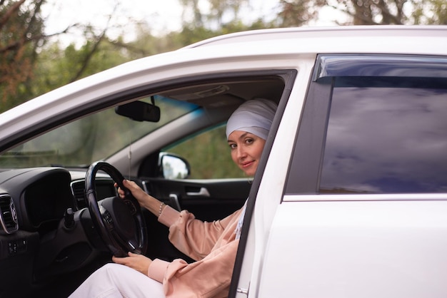 Mulher muçulmana Cutr está de pé perto do carro moderno