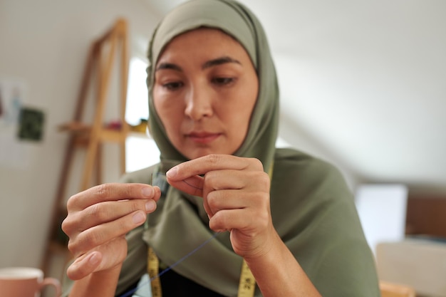 Mulher muçulmana de hijab enfiando agulha cfat e conceito de hobby